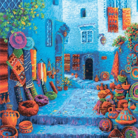 RIOLIS Colours of Morocco counted cross stitch kit showing a vibrant Moroccan street scene with textiles, pottery and blue buildings