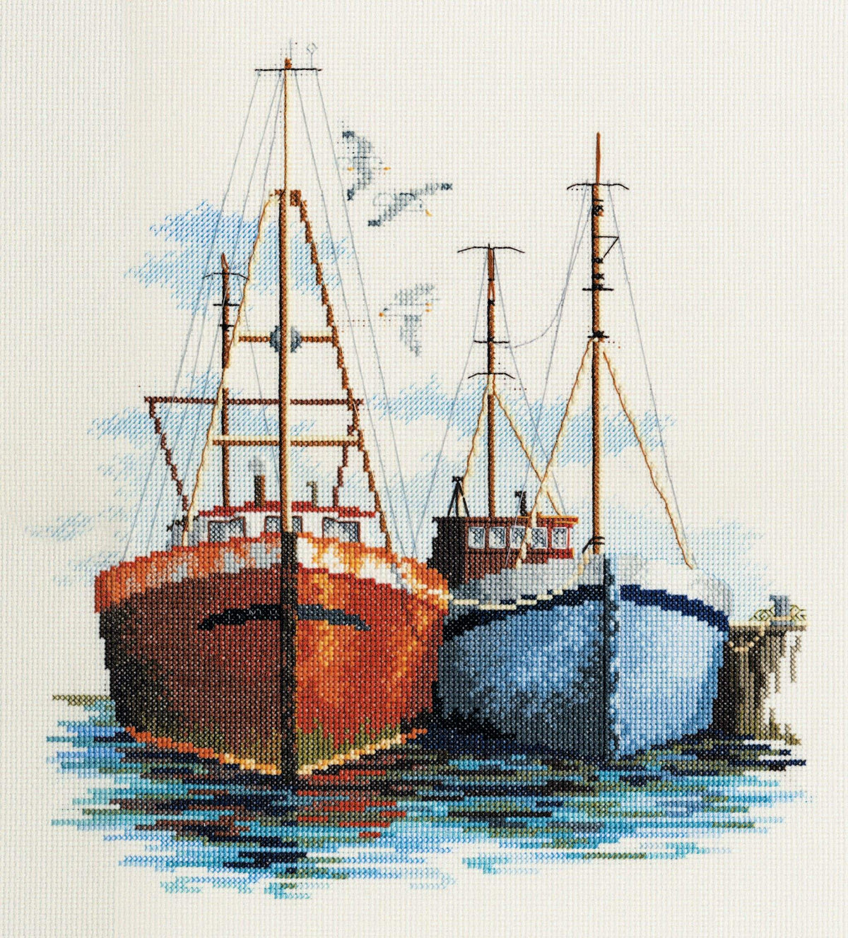 Fish Quay cross stitch showing two fishing boats docked with seagulls and water reflections.