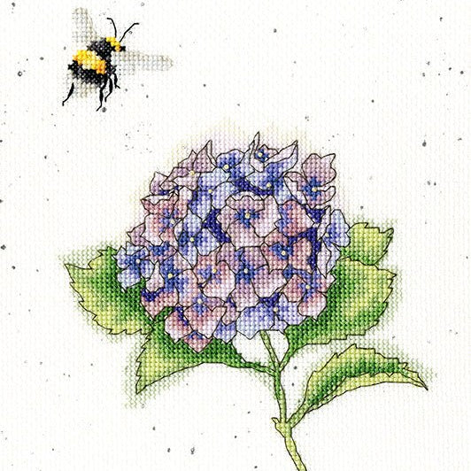 Cross stitch kit featuring a bumblebee and hydrangea design on speckled fabric