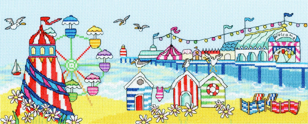 Bright seaside pier scene with striped beach huts, colorful Ferris wheel, helter-skelter, seagulls, and beach chairs cross stitch kit design
