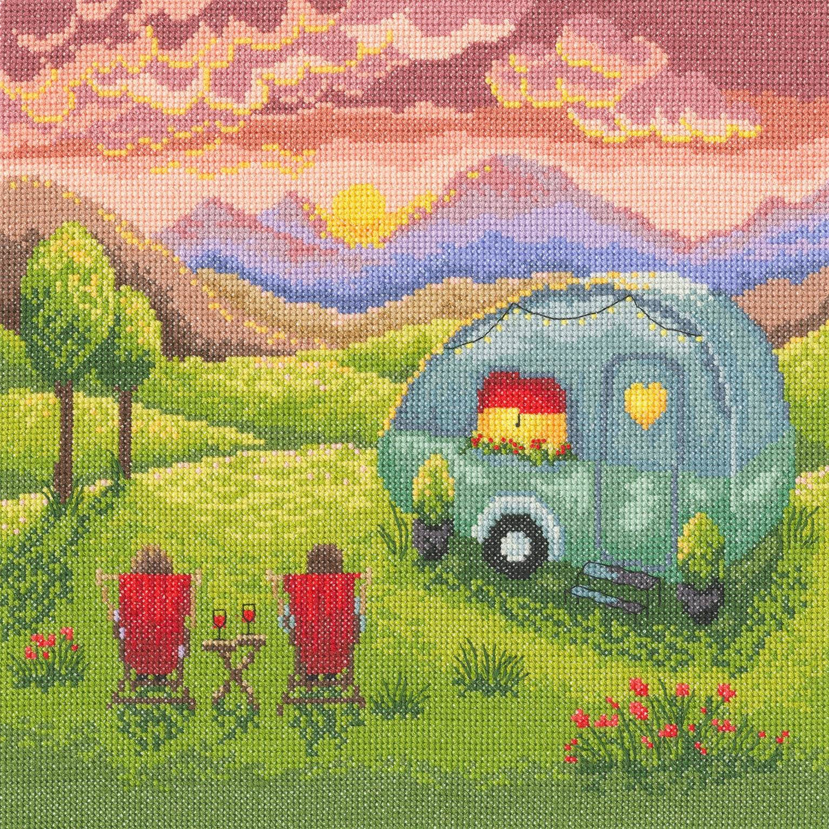 Counted cross stitch kit depicting a cozy caravan scene at sunset with two red chairs and green hills.