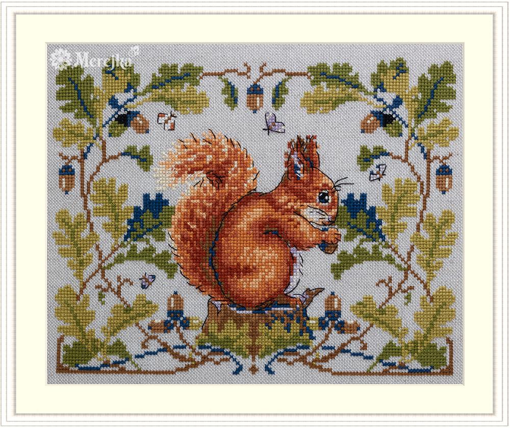 The Squirrel Cross Stitch Kit featuring a red squirrel on a tree stump eating an acorn with detailed foliage and acorn border design