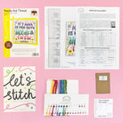 Needle and thread cross stitch kit with 14 count white Aida fabric, cotton threads, beads, needle, and instructions