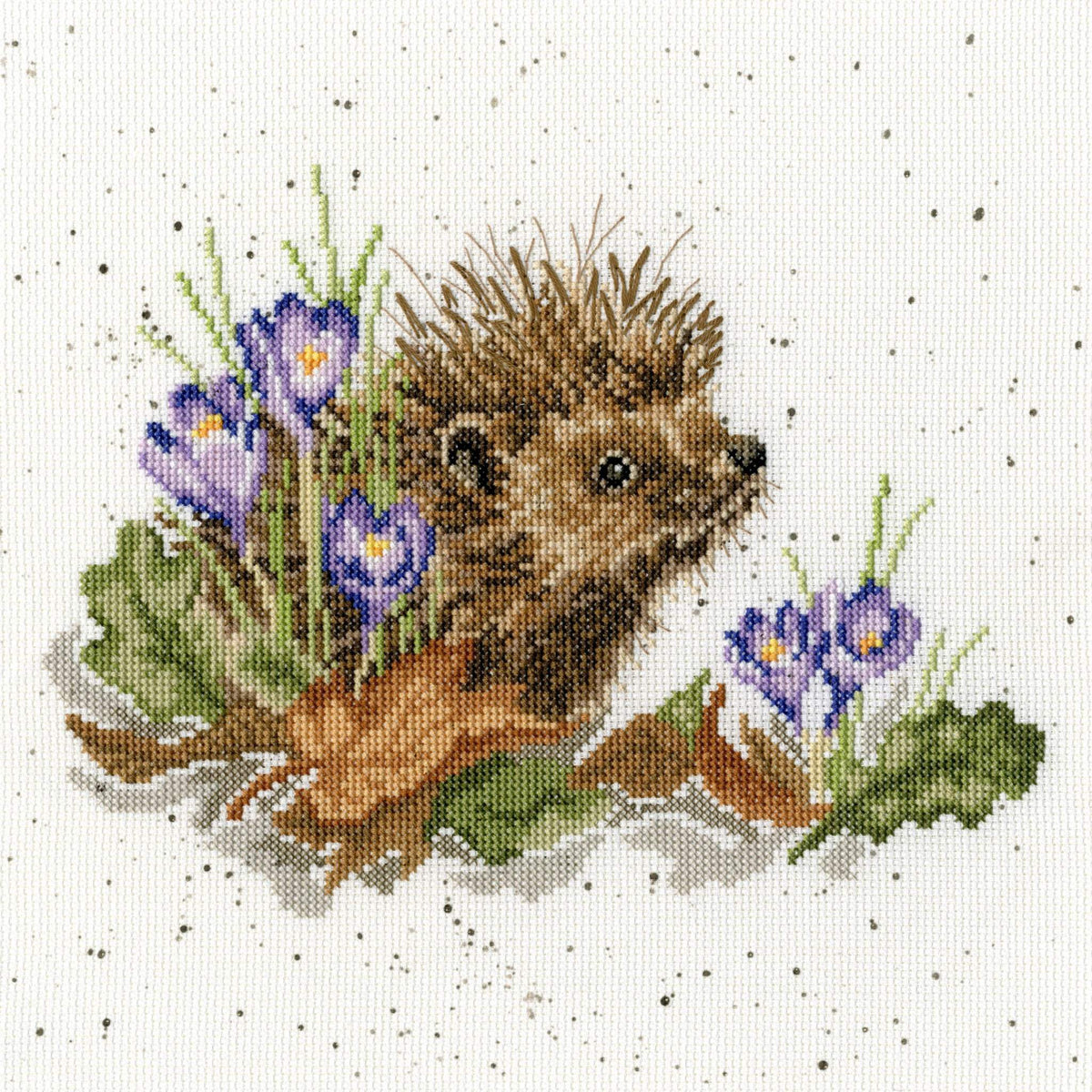 New Beginnings Cross Stitch Kit featuring a hedgehog with purple flowers and green leaves on speckled 14 count Aida fabric
